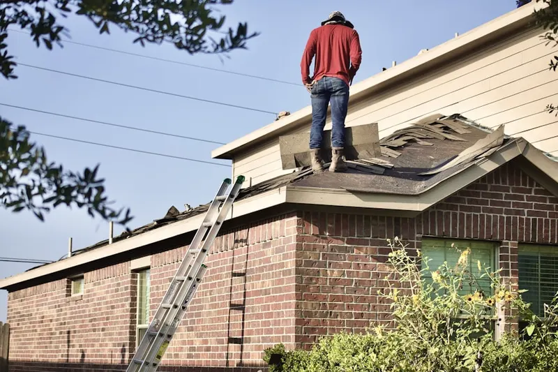 Professional roofer working on a residential roof in Lathrup Village